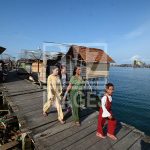Ibu-ibu dan gadis remaja suku Bajo berjalan di atas jembatan menuju pasar di Pulau Kabalutan, Kepulauan Togean, Tojo Unauna, Sulawesi Tengah. ANTARAFOTO/Basri Marzuki/18