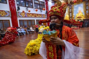 A Chinese citizen wearing traditional clothing during the lion dance staging after the Chinese Lunar New Year greeting at the Eka Dharma Manggala Temple in Palu, Central Sulawesi, Indonesia on January 24, 2020. Prayers are performed to welcome the Chinese Lunar New Year 2571/2020 and ask for blessings, safety and protection from the Yang Almighty. The lion dance attraction was also held as a symbol of good luck and blessings. (Photo by bmzIMAGES/Basri Marzuki)