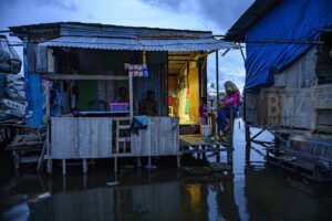 Warga beraktivitas di rumahnya yang digenangi banjir rob atau air pasang laut di Desa Tompe, Kecamatan Sirenja, Kabupaten Donngala, Sulawesi Tengah, Minggu (12/1/2020). Banjir air pasang yang masuk hingga kepemukiman warga itu disebabkan karena terjadinya penurunan permukaan tanah sedalam dua meter akibat gempa 7,4 SR yang berpusat di desa itu pada 28 September tahun lalu. Warga setempat terpaksa mengungsi ke tempat yang lebih tinggi dan kembali lagi ke rumah mereka setelah air surut. bmzIMAGES/Basri Marzuki