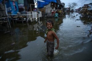 Seorang anak melintas di genangan banjir rob atau air pasang laut di Desa Tompe, Kecamatan Sirenja, Kabupaten Donngala, Sulawesi Tengah, Minggu (12/1/2020). Banjir air pasang yang masuk hingga kepemukiman warga itu disebabkan karena terjadinya penurunan permukaan tanah sedalam dua meter akibat gempa 7,4 SR yang berpusat di desa itu pada 28 September tahun lalu. Warga setempat terpaksa mengungsi ke tempat yang lebih tinggi dan kembali lagi ke rumah mereka setelah air surut. bmzIMAGES/Basri Marzuki