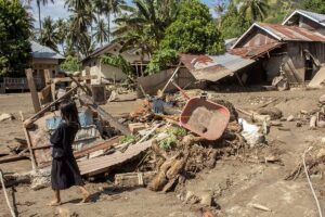 Seorang anak melintas di depan rumahnya yang ambruk dan tertimbun lumpur akibat banjir bandang di Desa Balongga, Kecamatan Dolo Selatan, Kabupaten Sigi, Sulawesi Tengah, Kamis (18/4/2024). Dua desa yakni Desa Balongga dan Desa Sambo di wilayah itu diterjang banjir bandang akibat intensitas hujan yang cukup tinggi di hulu sungai pada Rabu (17/4) malam dan menimbun sejumlah rumah-rumah warga, menghanyutkan ternak dan merusak ratusan hektar lahan pertanian. bmzIMAGES/Basri Marzuki
