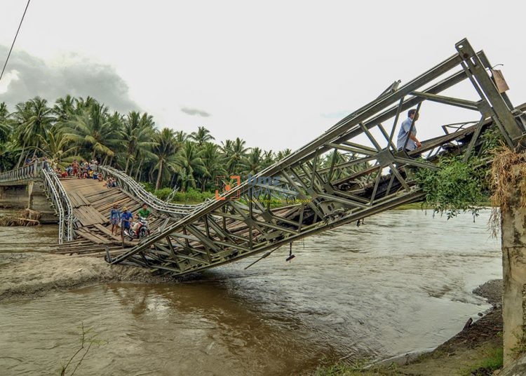Sejumlah warga melintas di jembatan yang ambrol di Desa Kaleke, Kecamatan Dolo Barat, Kabupaten Sigi, Sulawesi Tengah, Jumat (22/10/2010). Jembatan yang dibangun tahun 1996 tersebut ambrol setelah dilewati kendaraan berat yang tidak sesuai dengan kekuatan jembatan pada Rabu (20/10/2010) lalu. Tidak ada korban jiwa pada kecelakaan tersebut. bmzIMAGES/Basri Marzuki