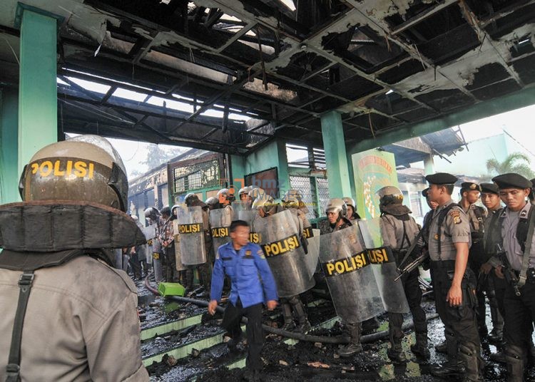 Sejumlah petugas bersiaga menyerbu ke dalam Lembaga Pemasyarakatan (Lapas) Kelas II Palu yang dibakar oleh para narapidana (Napi) di Palu, Sulawesi Tengah, Senin (4/4/2011). Lapas tersebut dibakar oleh napi yang dipicu oleh kematian seorang napi. Selain membakar Lapas, napi juga menyandera 2 sipir. 3 orang napi ditembak oleh aparat untukmengendalikan kerusuhan itu. bmzIMAGES/Basri Marzuki