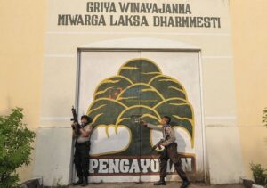 Sejumlah petugas polisi berjaga di pintu samping Lembaga Pemasyarakatan (Lapas) Kelas II Palu yang dibakar oleh para narapidana (Napi) di Palu, Sulawesi Tengah, Senin (4/4/2011). Lapas tersebut dibakar oleh napi yang dipicu oleh kematian seorang napi. Selain membakar Lapas, napi juga menyandera 2 sipir. 3 orang napi ditembak oleh aparat untukmengendalikan kerusuhan itu. bmzIMAGES/Basri Marzuki