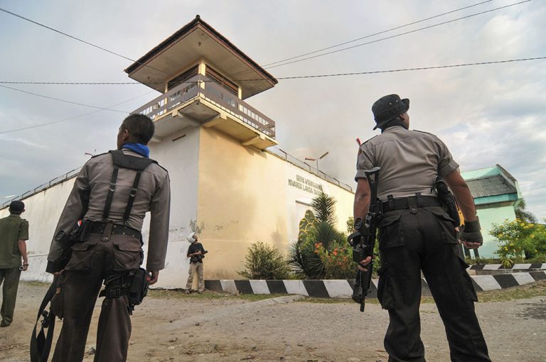 Sejumlah petugas berjaga di depan Lembaga Pemasyarakatan (Lapas) Kelas II Palu yang dibakar oleh para narapidana (Napi) di Palu, Sulawesi Tengah, Senin (4/4/2011). Lapas tersebut dibakar oleh napi yang dipicu oleh kematian seorang napi. Selain membakar Lapas, napi juga menyandera 2 sipir. 3 orang napi ditembak oleh aparat untukmengendalikan kerusuhan itu. bmzIMAGES/Basri Marzuki