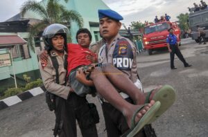 Seorang narapidana dibopong oleh petugas setelah tertembak di Lembaga Pemasyarakatan (Lapas) Kelas II Palu yang dibakar oleh para narapidana (Napi) di Palu, Sulawesi Tengah, Senin (4/4/2011). Lapas tersebut dibakar oleh napi yang dipicu oleh kematian seorang napi. Selain membakar Lapas, napi juga menyandera 2 sipir, 3 orang napi ditembak oleh aparat untukmengendalikan kerusuhan itu. bmzIMAGES/Basri Marzuki