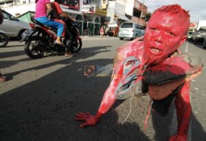 Seniman Endeng Mursalim (40) melakukan aksi art performance bertema "Sandal Jepit" di Jalan Hasanuddin Palu, Sulawesi Tengah, Sabtu (31/12/2011). Aksi itu sebagai bentuk keprihatianan atas kasus hukum yang menimpa AAL yang dituduh mencuri sandal jepit milik seorang anggota polisi. bmzIMAGES/Basri Marzuki