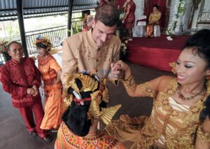Pasangan Jefl Logan Comaway berkewarganegaraan Amerika Serikat dan Melisa Widebline Sambara Dewi, WNI menyelipkan uang pada penari saat melangsungkan pernikahan menggunakan adat Kulawi di Palu, Sulawesi Tengah, Sabtu (4/1/2012). Perkawinan campuran makin marak dilakukan setelah peraturan perundangan memberi kelonggaran untuk itu. bmzIMAGES/Basri Marzuki